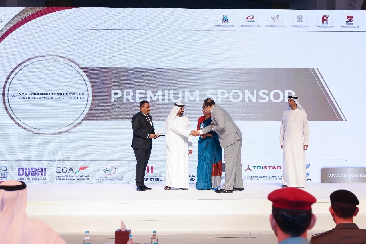 Two people shaking hands on stage in front of a Premium Sponsor backdrop